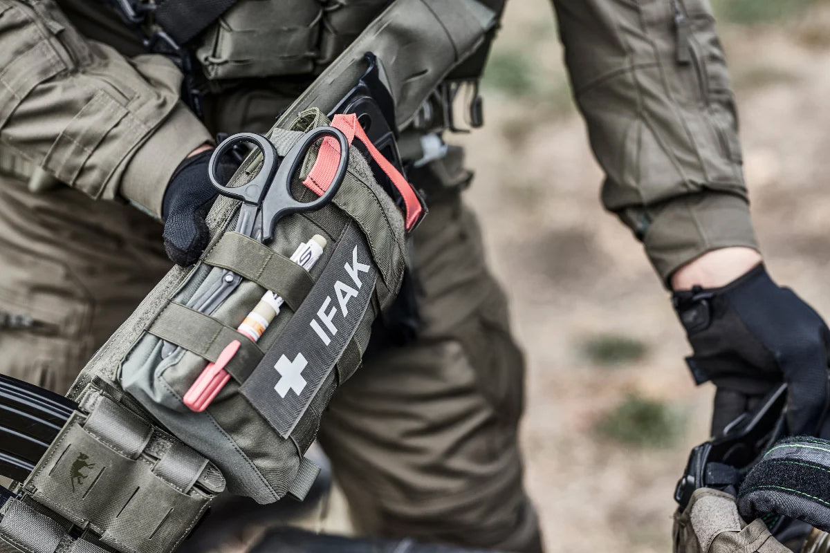 Operator accessing IFAK pouch in the field