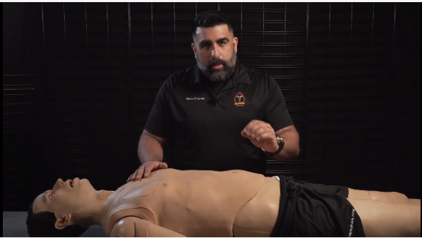 MED-TAC founder demonstrating medical training technique with CPR mannequin