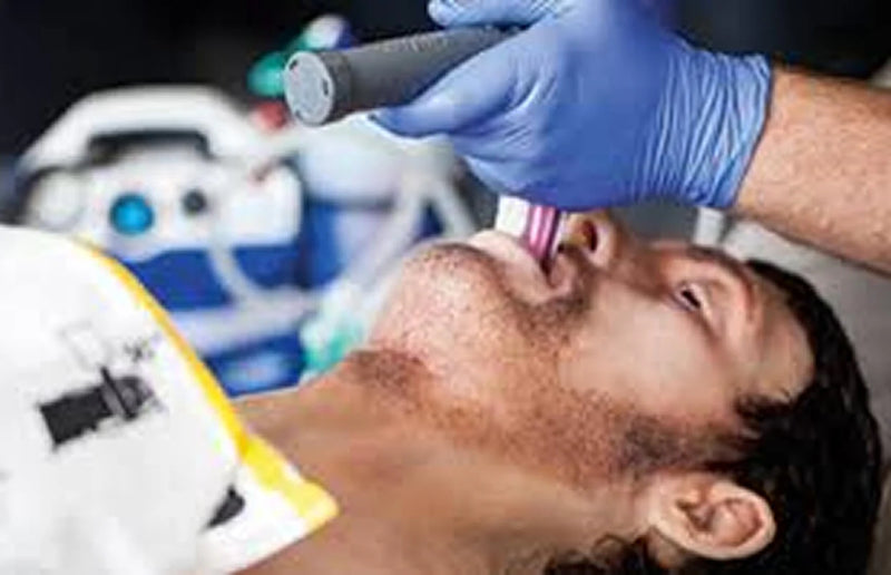 Medical professional wearing blue nitrile gloves performing intubation